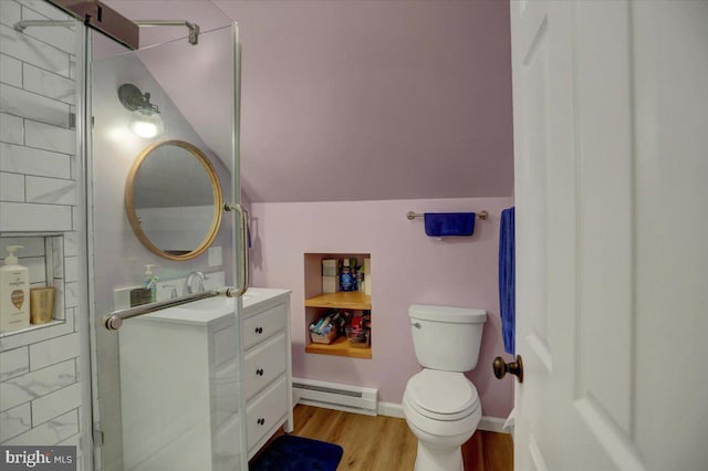 bathroom featuring toilet, wood finished floors, vanity, vaulted ceiling, and baseboard heating