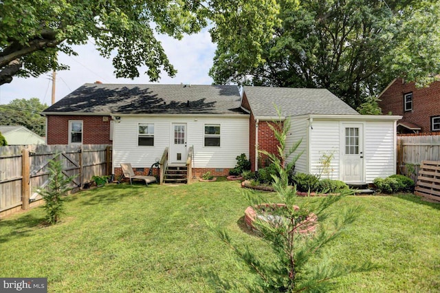 rear view of property featuring roof with shingles, a yard, entry steps, crawl space, and a fenced backyard