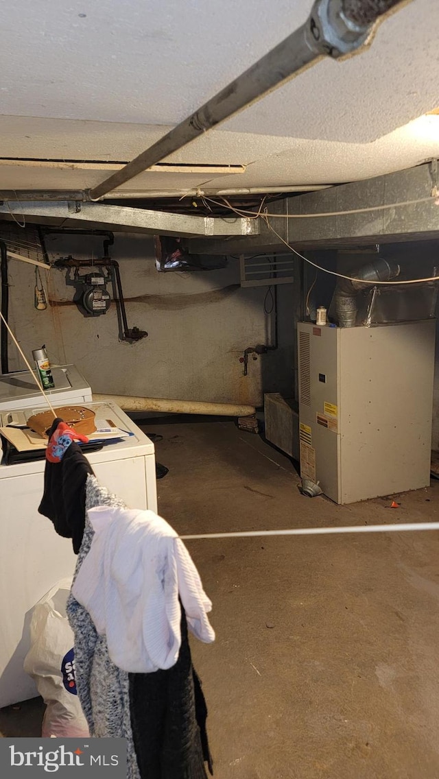 unfinished below grade area featuring washing machine and dryer and heating unit