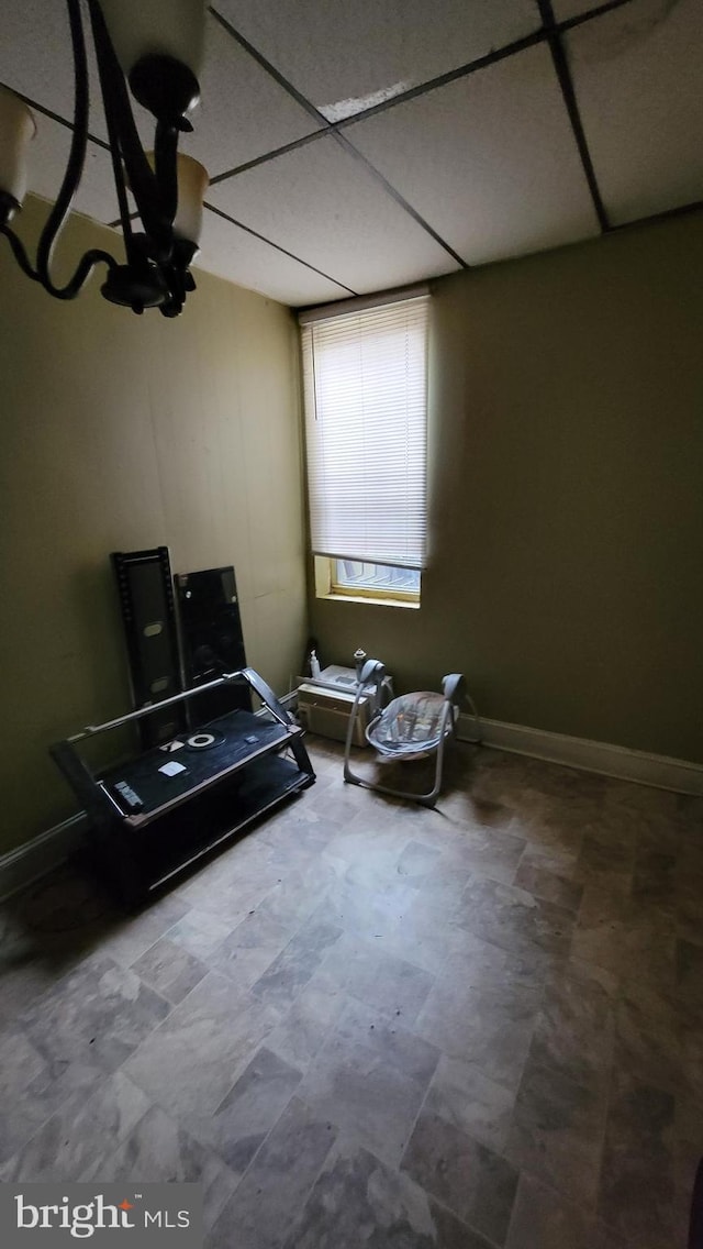 interior space with baseboards and a drop ceiling