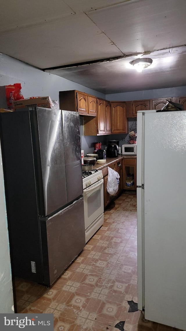 kitchen with white appliances, brown cabinets, and light floors