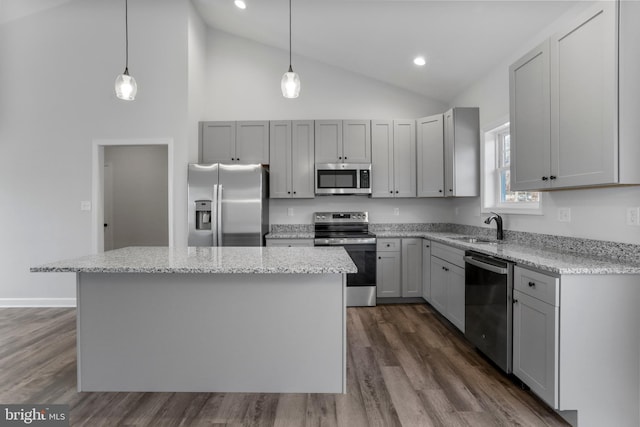 kitchen featuring dark wood-style floors, gray cabinets, appliances with stainless steel finishes, a sink, and a kitchen island