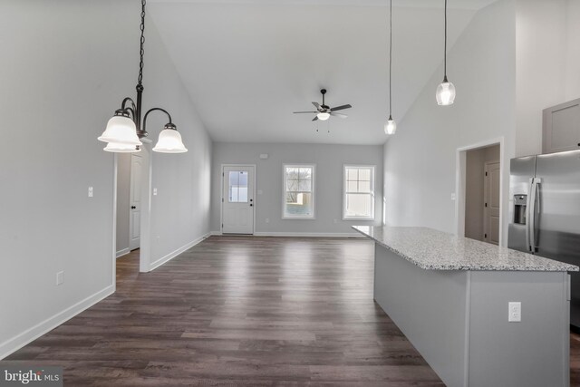 kitchen with dark wood-style floors, a kitchen island, stainless steel fridge, and a ceiling fan