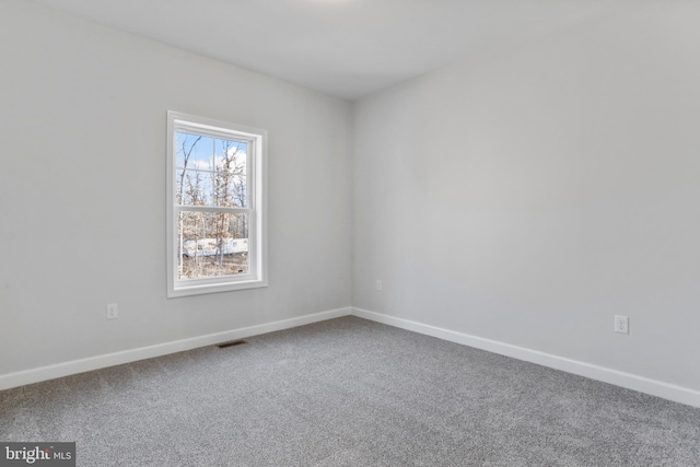 unfurnished room featuring carpet floors, visible vents, and baseboards