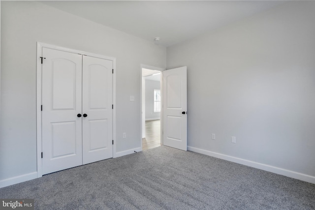 unfurnished bedroom with carpet floors, baseboards, and a closet