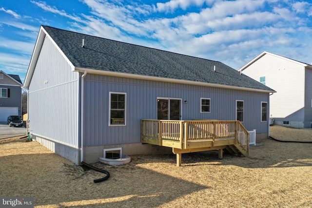 rear view of property featuring roof with shingles and a wooden deck