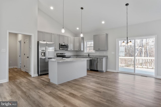 kitchen featuring appliances with stainless steel finishes, gray cabinets, a kitchen island, and wood finished floors