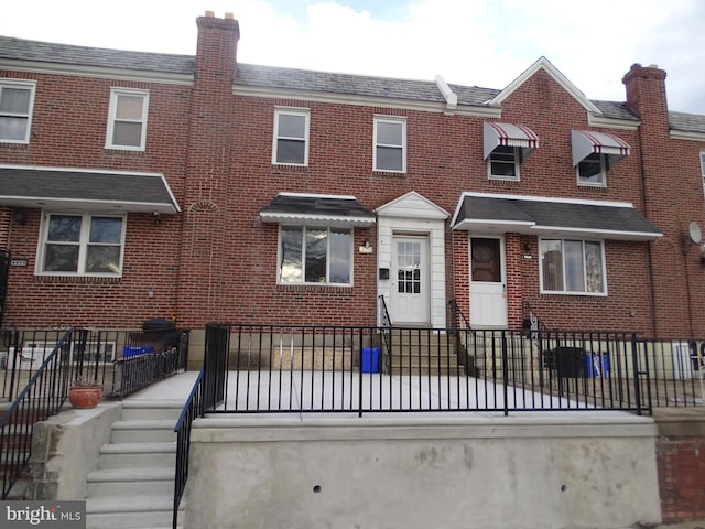 multi unit property featuring brick siding and fence