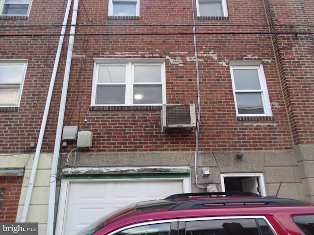 view of side of home featuring a garage and brick siding