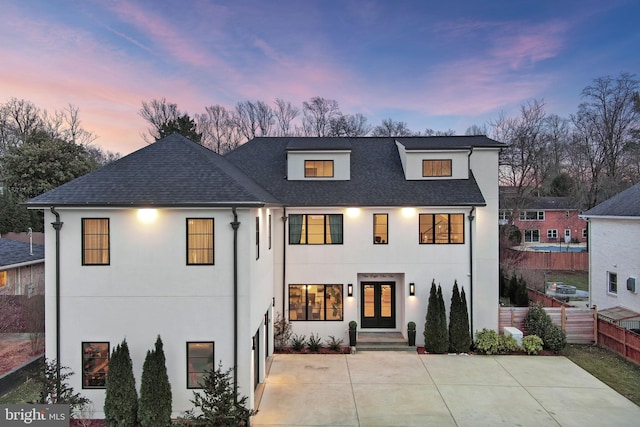 view of front of home featuring stucco siding, a shingled roof, fence, and french doors