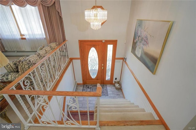 entryway with a high ceiling, stairs, and a chandelier