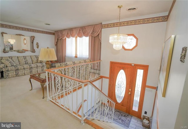 foyer with stairs, visible vents, and a notable chandelier