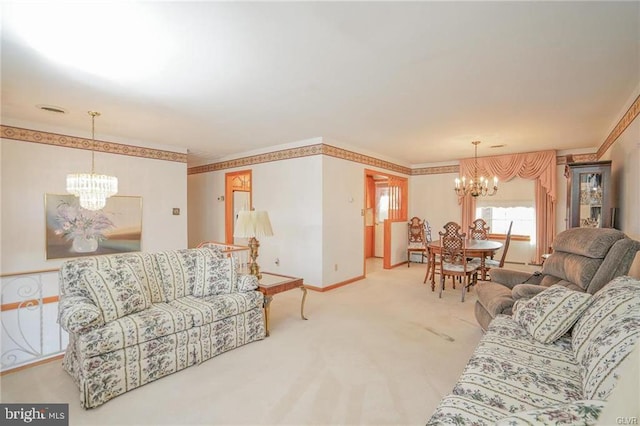 carpeted living room with crown molding, baseboards, and an inviting chandelier