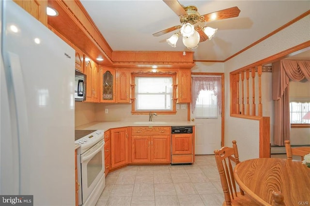 kitchen with light countertops, baseboard heating, ornamental molding, a sink, and white appliances