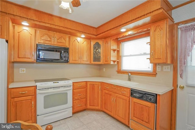 kitchen featuring white appliances, glass insert cabinets, ornamental molding, light countertops, and a sink