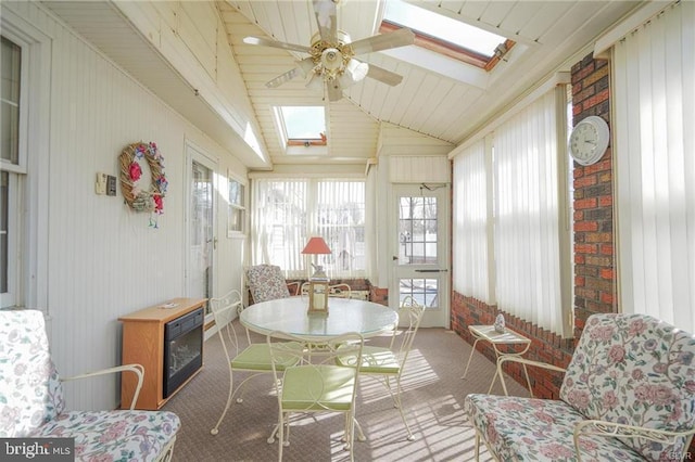 sunroom featuring lofted ceiling with skylight and ceiling fan