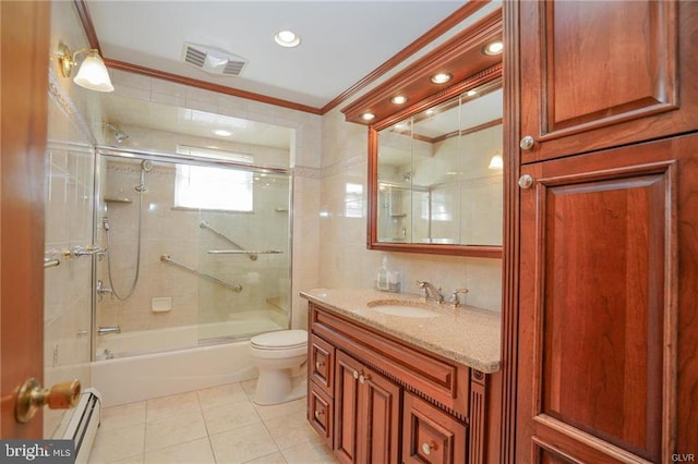 bathroom featuring visible vents, ornamental molding, baseboard heating, vanity, and tile walls