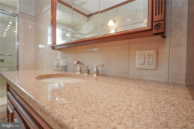 bathroom with tile walls, crown molding, backsplash, and vanity