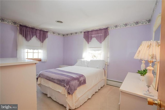 bedroom featuring light carpet, a baseboard radiator, and visible vents