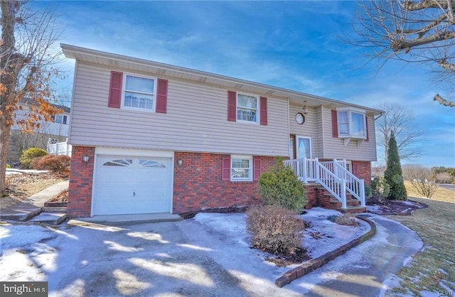 split foyer home featuring an attached garage and brick siding