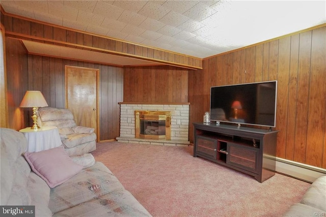 living room with a baseboard heating unit, carpet flooring, wood walls, and a stone fireplace