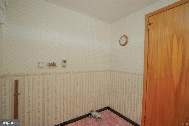 washroom with wallpapered walls, ornamental molding, and carpet flooring