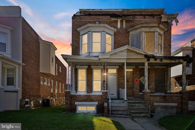 view of front of home featuring a porch, cooling unit, and brick siding