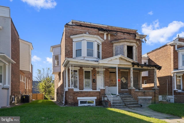 view of front of house with a porch, cooling unit, brick siding, fence, and a front lawn