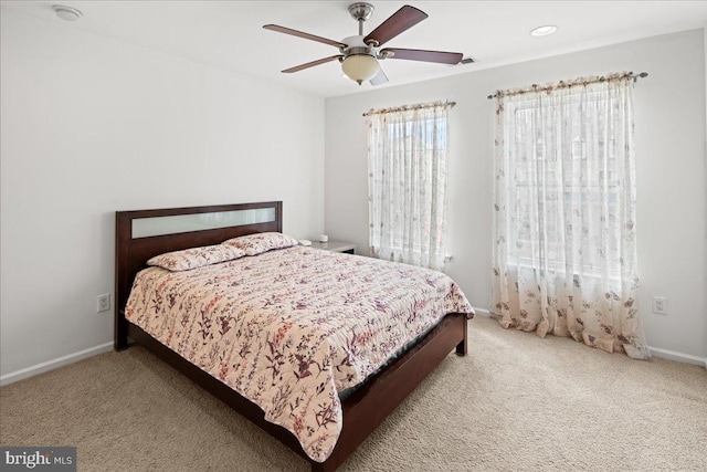 bedroom with a ceiling fan, baseboards, and carpet floors