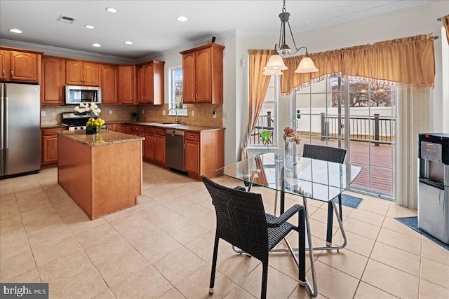 kitchen with light tile patterned floors, visible vents, a sink, stainless steel appliances, and brown cabinets