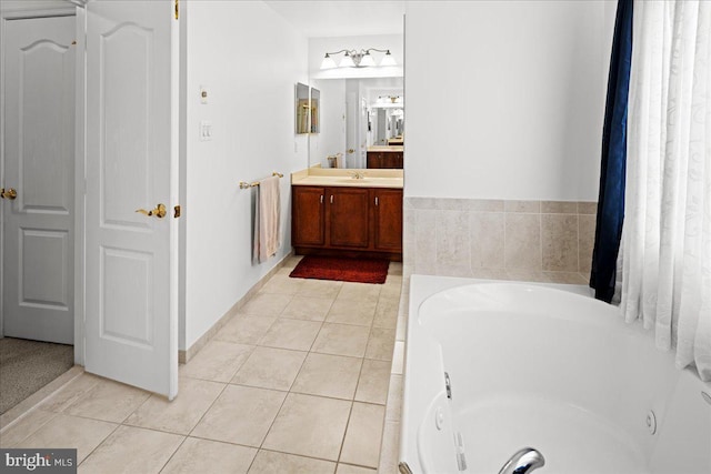 full bathroom with tile patterned floors, vanity, baseboards, and a whirlpool tub