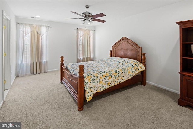 bedroom featuring baseboards, light colored carpet, and ceiling fan