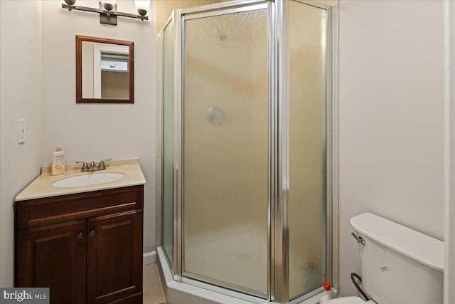 full bath with vanity, a shower stall, and toilet