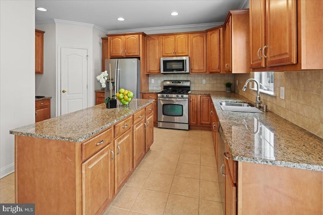 kitchen featuring light stone counters, appliances with stainless steel finishes, crown molding, and a sink