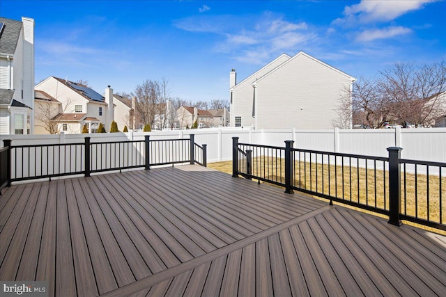 wooden deck with a residential view and a fenced backyard