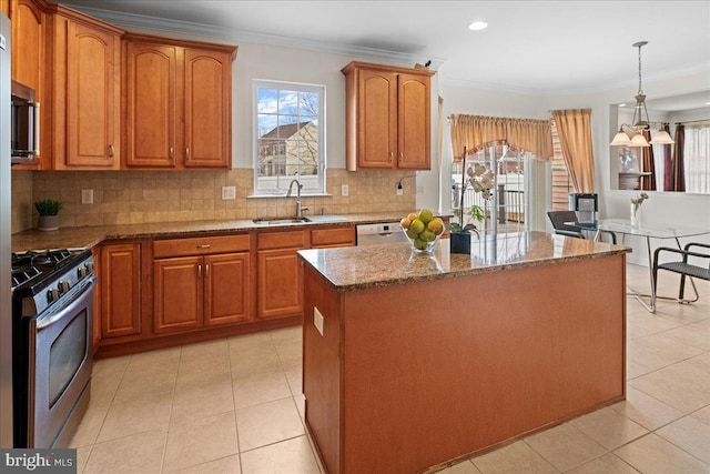 kitchen featuring stone counters, gas stove, a kitchen island, and crown molding