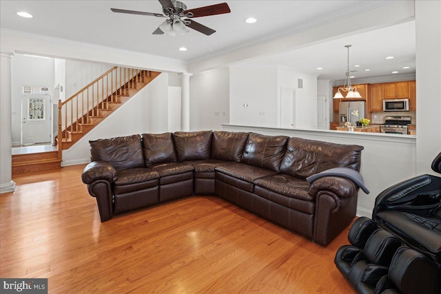 living room with stairs, ornamental molding, decorative columns, recessed lighting, and light wood-style flooring