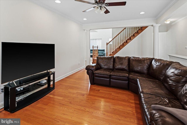 living room with light wood-type flooring, stairway, ornamental molding, and ornate columns