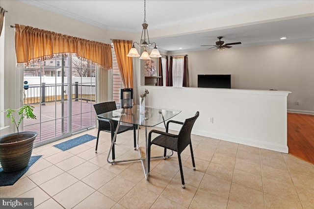 dining room with tile patterned flooring, ceiling fan with notable chandelier, baseboards, and ornamental molding