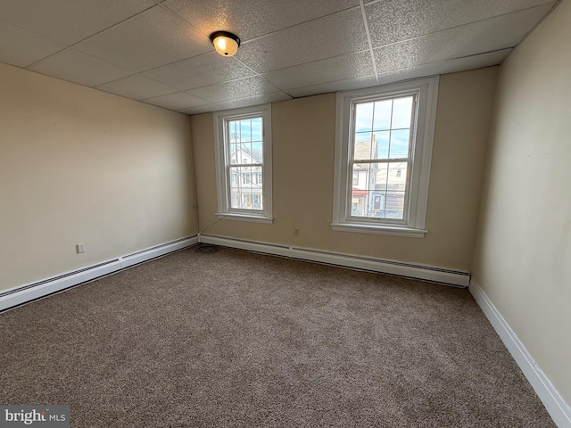 spare room with carpet, a paneled ceiling, baseboard heating, and baseboards