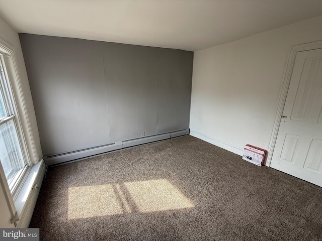 unfurnished room with carpet and a baseboard heating unit