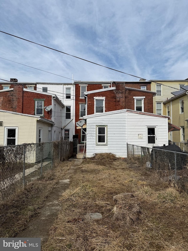 back of house with fence and brick siding