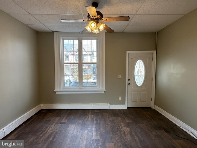 entryway with dark wood-type flooring, a drop ceiling, a ceiling fan, and baseboards