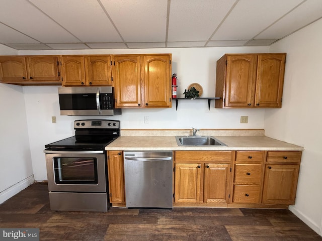 kitchen with appliances with stainless steel finishes, brown cabinets, dark wood-type flooring, open shelves, and a sink