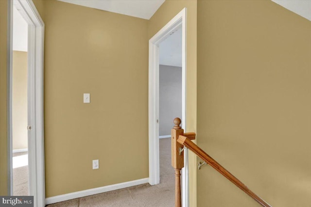 hall featuring carpet, an upstairs landing, and baseboards