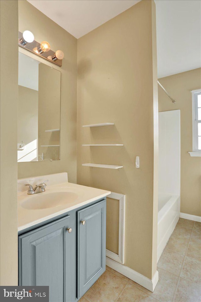 bathroom featuring tile patterned floors, vanity, shower / tub combination, and baseboards