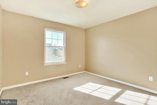 carpeted empty room with baseboards