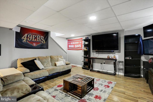 living area featuring baseboards, a paneled ceiling, and wood finished floors