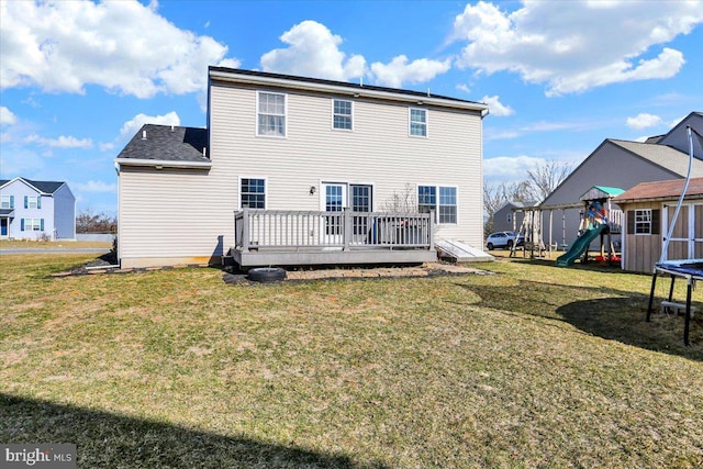 back of property featuring a lawn, a playground, and a deck