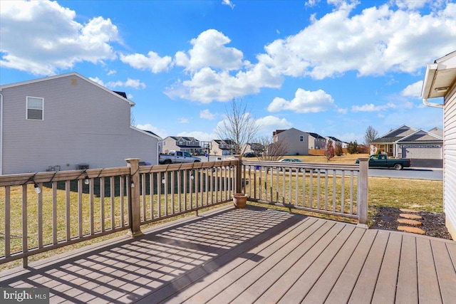 wooden deck featuring a residential view and a lawn